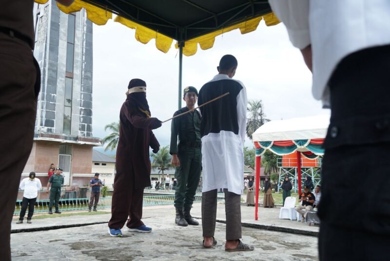 Pelanggar syariat Islam sedang dicambuk oleh algojo yang berlangsung di Halaman Masjid Agung Al Munawwarah, Kota Jantho, Aceh Besar, Rabu (26/02/2025) siang. FOTO/MC ACEH BESAR
