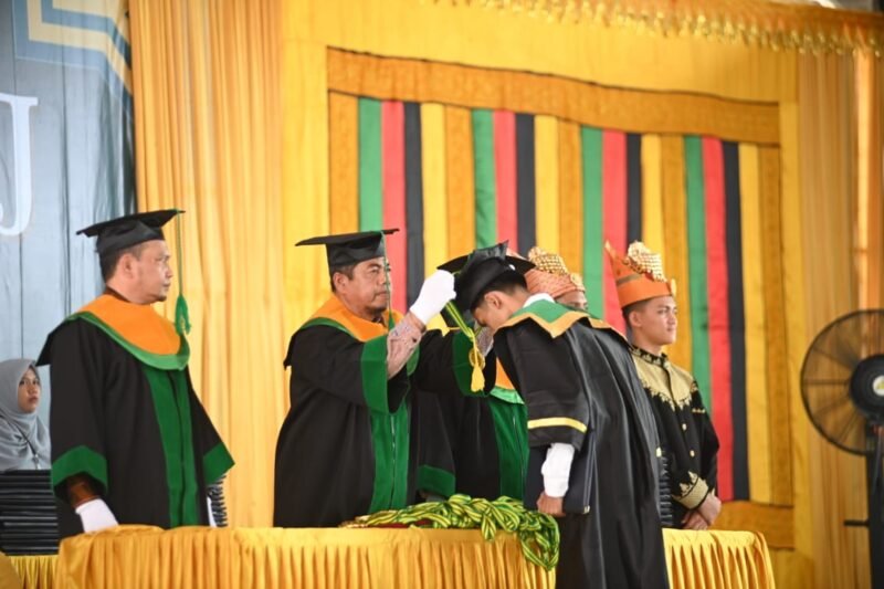 Kadisdik Dayah Aceh Besar, Abu Bakar, S.Ag, mengenakan Samir kepada peserta wisuda RIAB Angkatan XXVI Tahun Pelajaran 2024/2025 di Komplek RIAB, Gampong Gue Gajah, Kecamatan Darul Imarah, Aceh Besar, Sabtu, (19/4/2025). FOTO/MC ACEH BESAR