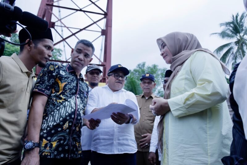 Ketua Tim Penggerak PKK Aceh, Marlina Muzakir, didampingi Kepala Dinas PUPR Aceh, Mawardi, dan Wakil Bupati Aceh Utara, Tarmizi meninjau lokasi Jembatan Krueng Sawang di Kecamatan Sawang, Aceh Utara, Selasa, 22/4. Jembatan tersebut ambruk ke sungai pada awal tahun 2025 akibat tergerus derasnya arus sungai saat pembongkaran. Foto: Biro Adpim  Setda Aceh