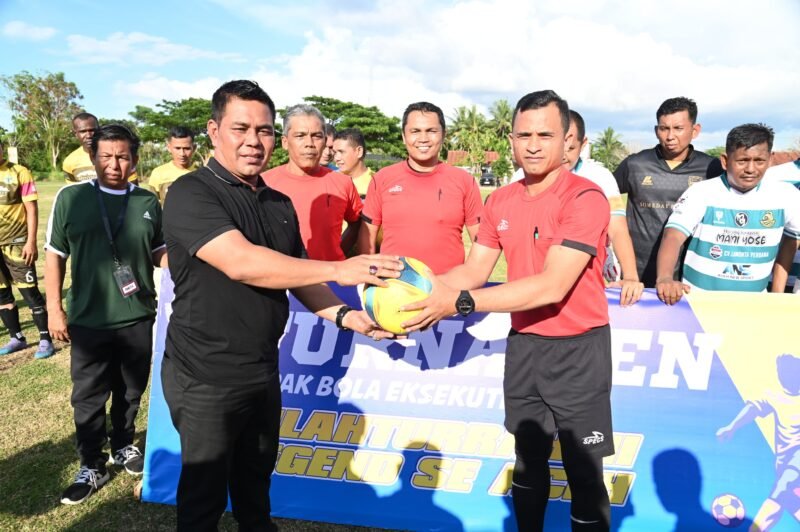 Bupati Aceh Besar, H Syech Muharram Idris menyerahkan bola kepada juri dalam Trunamen Sepakbola sepakbola Eksekutif dalam rangka Silaturrahmi di Lapangan Sepakbola Meunasah Tuha, Kecamatan Peukan Bada, Aceh Besar, Sabtu (26/04/2025). FOTO/MC ACEH BESAR
