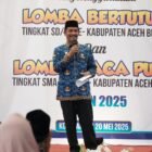 Wakil Bupati Aceh Besar Drs Syukri menyampaikan sambutan sekaligus membuka Lomba Literasi Bertutur tingkat SD/MI Se-Aceh Besar di Halaman Dinas Perpustakaan dan Kearsipan, Kota Jantho, Selasa (20/05/2025).FOTO/MC ACEH BESAR