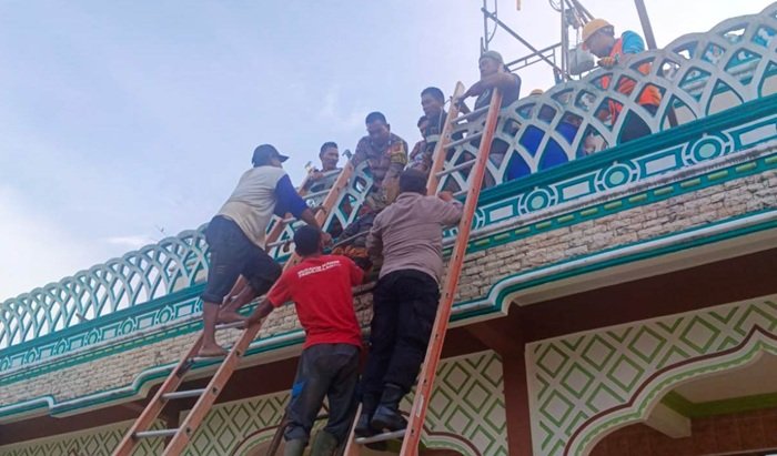 Polisi bersama warga mengevakuasi korban tersengat listrik saat bekerja membuat kubah masjid di Gampong Beusa Meurano, Peureulak, Aceh Timur, Rabu (18/6/2025) sore. (Foto: Dok Polsek)