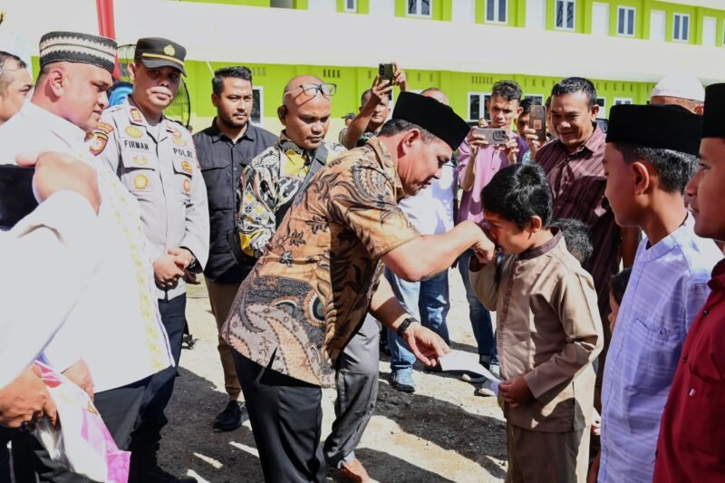 Bupati Aceh Besar, H Syech Muharram Idris menyerahkan santunan kepada anak yatim dalam acara Peletakan Batu Pertama Pembangunan Masjid Nuur AR Radhiyyah RSU Putri Bidadari Aceh di Gampong Lamreung, Kecamatan Darul Imarah, Aceh Besar, Jumat (13/06/2025). FOTO/MC ACEH BESAR