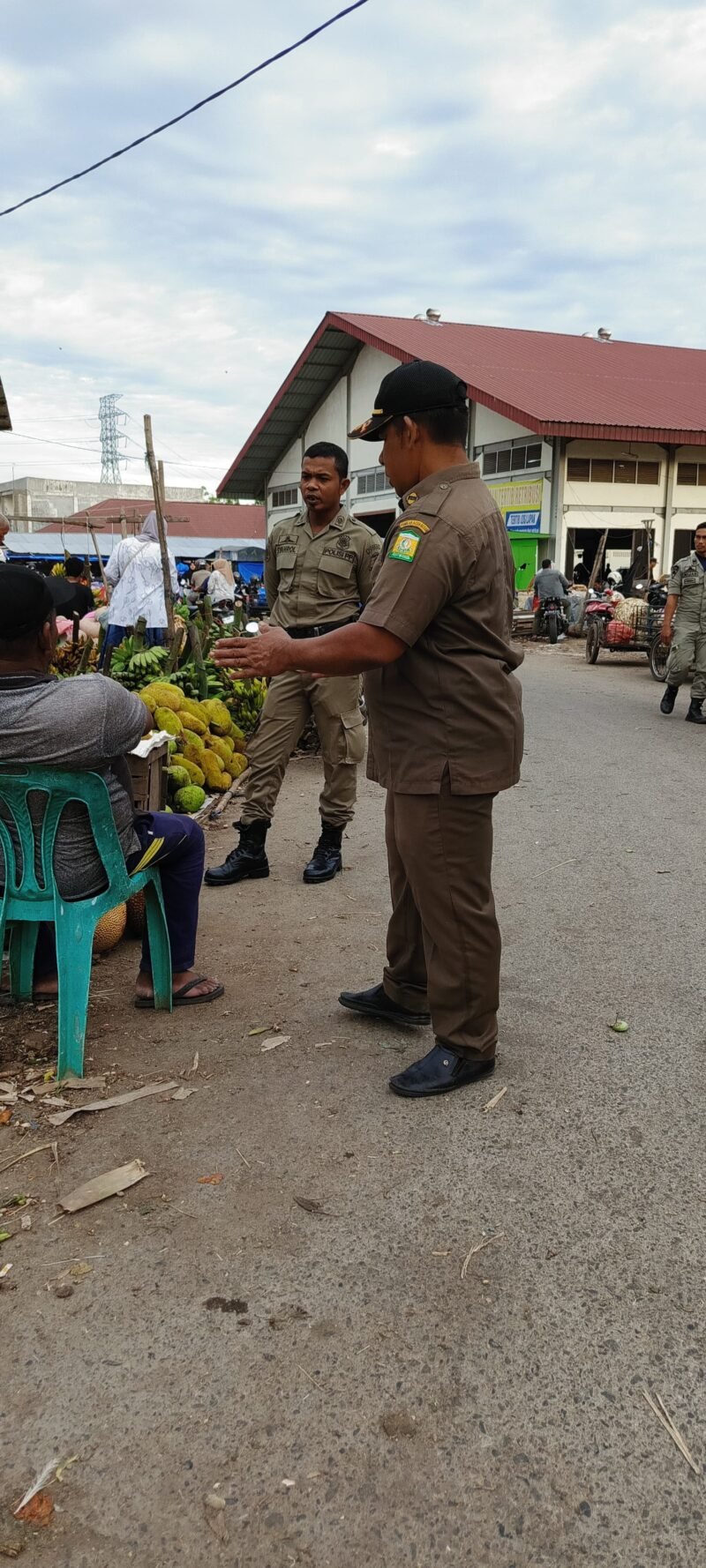 Petugas Satpol PP dan WH Aceh Besar mengimbau para pedagang agar tidak berjualan di badan jalan, Pasar Induk Lambaro, Kecamatan Ingin Jaya, Kabupaten Aceh Besar, Senin (16/6/2025). FOTO/ MC ACEH BESAR
