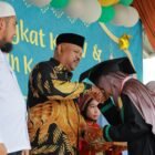 Kepala Dinas Syariat Islam Rusdi S.Sos MSi menyampaikan selamat kepada santri Tasyakkur Kenaikan Tingkat IV dan Wisuda III TPQ Baburridha di halaman Mesjid Lam Ilie, Indrapuri, Minggu (22/06/2025). FOTO/MC ACEH BESAR