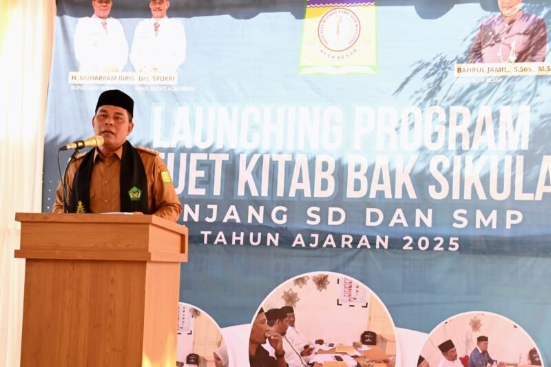 Bupati Aceh Besar, H Syech Muharram Idris memberi sambutan sekaligus Launching Program Beuet Kitab Bak Sikula di.SMP Negeri 1 Lampeuneurut, Kecamatan Darul Imarah, Aceh Besar, Senin (28/07/2025). FOTO/MC ACEH BESAR