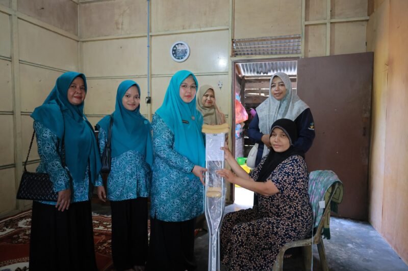 Ketua TP PKK Aceh Besar Hj Rita Mayasari, menyerahkan bantuan tongkat kepada penyandang disabilitas fisik, di Gampong Meunasah Mon Cut, Kemukiman Lamlhom, Kecamatan Lhoknga, Kabupaten Aceh Besar, Senin (28/7/2025). FOTO/ MC ACEH BESAR