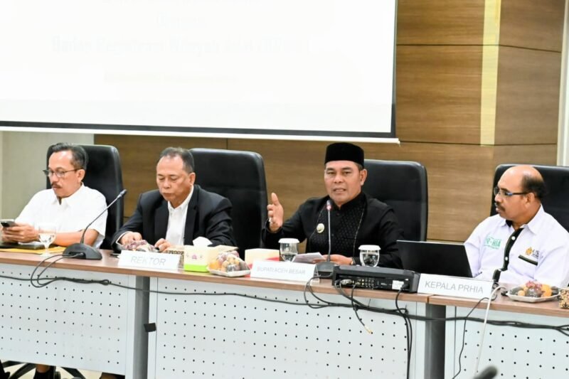 Bupati Aceh Besar, H Syech Muharram Idris memberikan sambutan dan paparan pada acara Kick off Meeting Riset Tenurial Subyek dan Objek Masyarakat Hukum Adat di Aula Balai Senak Lt 2 USK, Darussalam, Banda Aceh, Jumat (22/08/2025). FOTO/MC ACEH BESAR