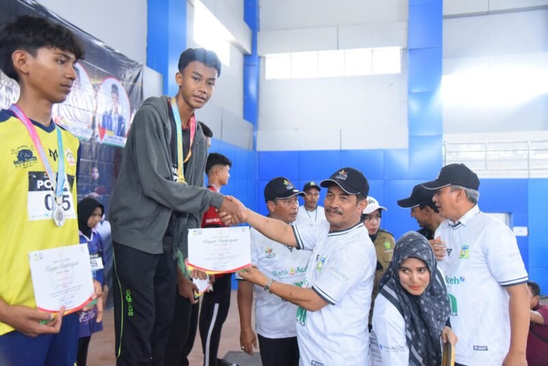 Wakil Bupati Aceh Besar Drs. H. Syukri A Jalil mengalungi medali dan menyerahkan piagam penghargaan kepada atlet olahraga atletik para peraih juara PORKAB Aceh Besar Tahun 2025 di Jantho Sport City (JSC), Selasa (9/9/2025). Foto : Dok
Mc Humas Aceh Besar