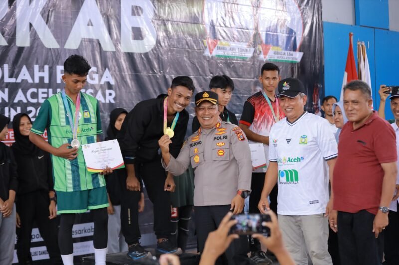 Kapolres Aceh Besar AKBP Sujoko SIK MH, didampingi Kadisparpora Aceh Besar Abdullah SSos, menyerahkan medali Porkab Aceh Besar, kepada para juara cabor Atletik putra, di JSC Kota Jantho, Aceh Besar, Rabu (10/9/2025). FOTO/ PROKOPIM PEMKAB ACEH BESAR