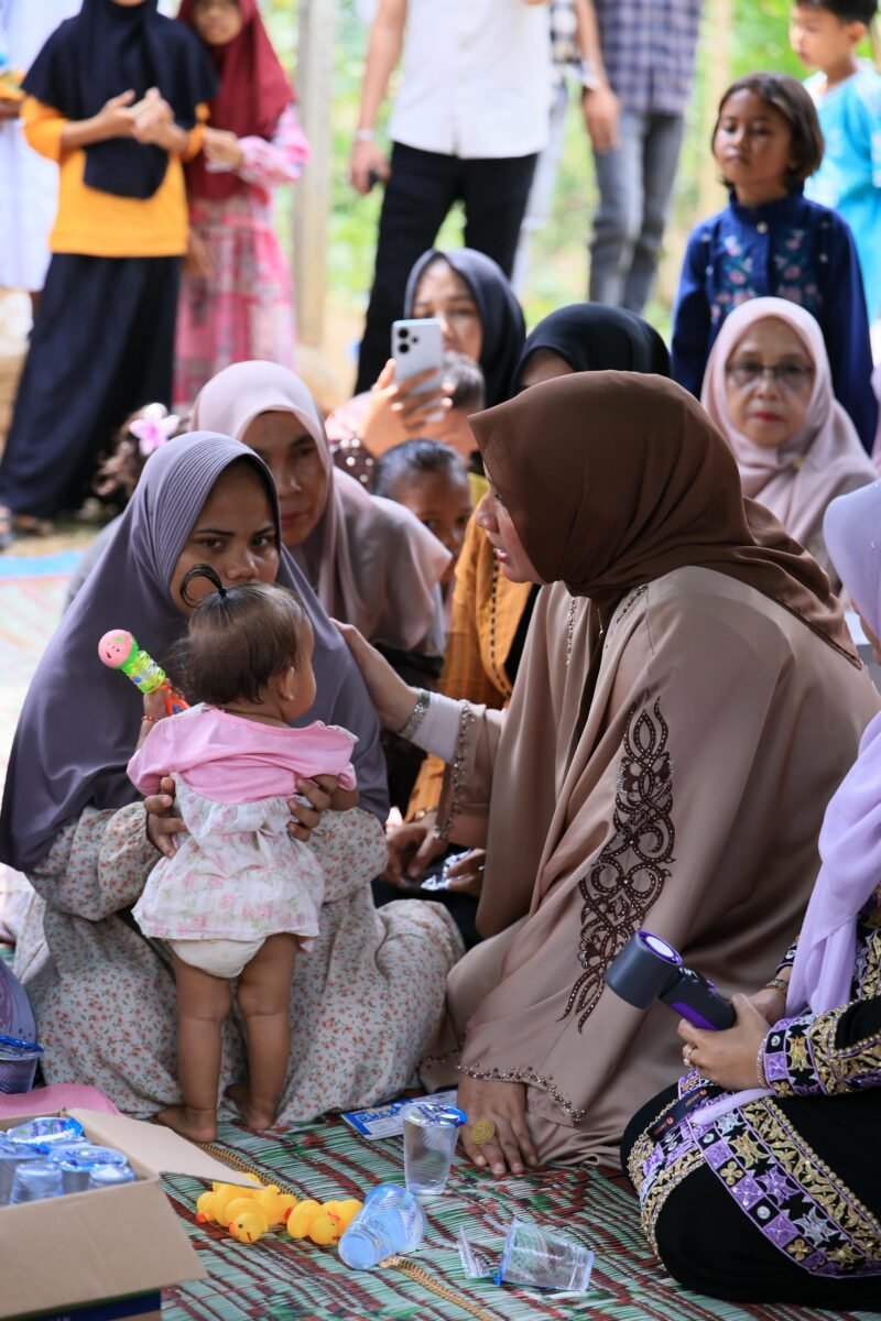 Istri Gubernur Aceh, Marlina atau akrab disapa Kak Ana, memberikan bantuan rumah layak huni dan uang tunai untuk keluarga almarhum Bustamam (26), kurir paket korban pembunuhan di Aceh Timur kepada istri almarhum Ismi (25) dan ibu kandung almarhum Halimah saat berkunjung ke rumah duka di Desa Bantayan Barat, Kecamatan Idi Tunong, Aceh Timur, pada Minggu, (14/9/2025). Foto ; Dok. Biro Adpim Setda Aceh