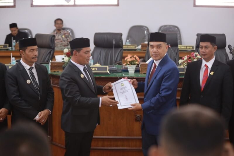 Bupati Aceh Besar Muharram Idris menyerahkan nota keuangan rancangan qanun tentang perubahan anggaran pendapatan dan belanja Kabupaten Aceh Besar tahun 2025 pada rapat paripurna ke-7 DPRK Aceh Besar masa persidangan ke-1 tahun sidang 2025-2026 diterima Ketua DPRK Aceh Bedar Abdul Mukcti, di Gedung DPRK Aceh Besar, Kota Jantho, Rabu (25/9/2025). FOTO/MC ACEH BESAR