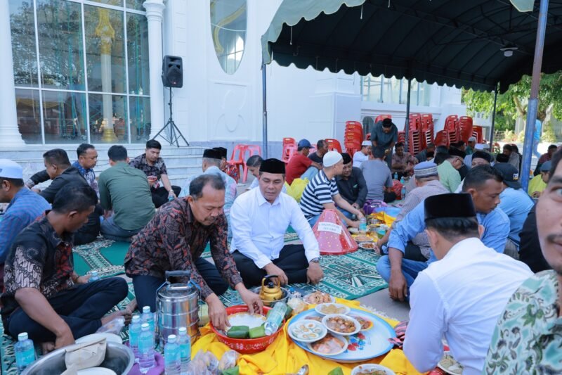 Bupati Aceh Besar H. Muharram Idris menikmati hidangan Maulid Nabi Muhammad SAW 1447 H di Masjid Rahmatullah Lampuuk, Kecamatan Lhoknga, Aceh Besar, Kamis (25/9/2025). FOTO/MC ACEH BESAR