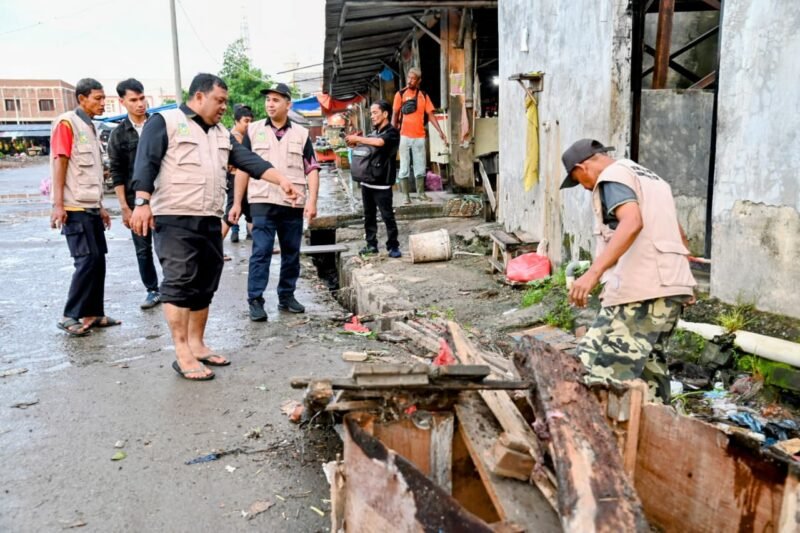 Plt Kadiskomugdag Aceh Besar, Drs Sulaimi MSi bersama staf, Satpol PP dan WH dan DLH membongkar lapak pedagang yang berjualan di pinggir jalan untuk lahan parkir di Pasar Induk Lambaro, Kecamatan Ingin Jaya, Aceh Besar, Selasa (12/11/2025). FOTO/MC ACEH BESAR