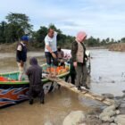 Ketua TP PKK Aceh, Marlina Muzakir (Kak Na), menumpang perahu nelayan menyeberangi Krueng Peusangan untuk mengantarkan bantuan ke Gampong Kubu, Kecamatan Peusangan Siblah Krueng, yang terisolir akibat putusnya jembatan penghubung, Minggu (14/12/2025).