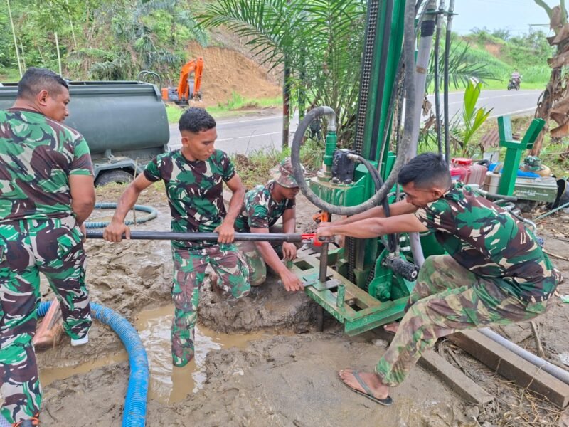 Sejumlah prajurit TNI berseragam lengkap sedang mengoperasikan alat berat pengeboran atau peralatan khusus lainnya untuk membuat sumur bor Selasa, (16/12/2025).

