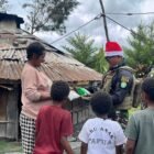 Prajurit Satgas Yonif 112/DJ Pos Kp 55 saat bercengkrama dan membagikan jajanan kepada anak-anak di Kampung Kalian Banak, Distrik Pagaleme, Puncak Jaya, Senin (22/12/2025).