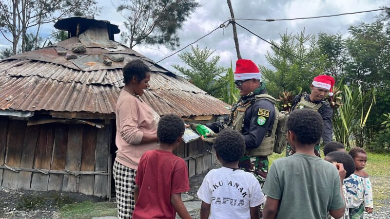 Prajurit Satgas Yonif 112/DJ Pos Kp 55 saat bercengkrama dan membagikan jajanan kepada anak-anak di Kampung Kalian Banak, Distrik Pagaleme, Puncak Jaya, Senin (22/12/2025).