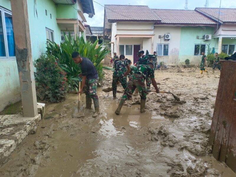 Personel gabungan dari Koramil 06/Manyak Payed, Yonif TP 853/BRB, Brigif 25/Siwah, dan Yonif RK 111/KB bahu-membahu membersihkan sisa lumpur di Puskesmas Manyak Payed, Aceh Tamiang, Kamis (25/12/2025). 