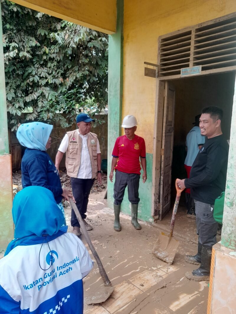 Plt. Kepala Dinas Pendidikan Aceh, Murtalamuddin, S.Pd., M.S.P (tengah), bersama pengurus IGI Aceh saat membantu membersihkan sisa lumpur pascabanjir di salah satu ruang kelas di Aceh Tamiang, Minggu (29/12/2025).
