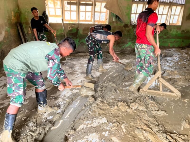 Sejumlah prajurit Satgas Penanggulangan Bencana Alam Yonif 115/ML bersama warga bergotong royong membersihkan sisa material banjir bandang di SD Negeri 04 Kuala Simpang, Aceh Tamiang, Minggu (4/1/2026). 
