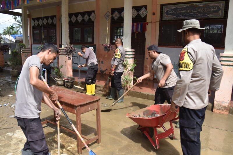 Foto: Puluhan personel Polres Bireuen bergotong royong membersihkan lumpur dan sampah di SD Negeri 2 Kuta Blang pascabanjir, Minggu (18/1/2026).