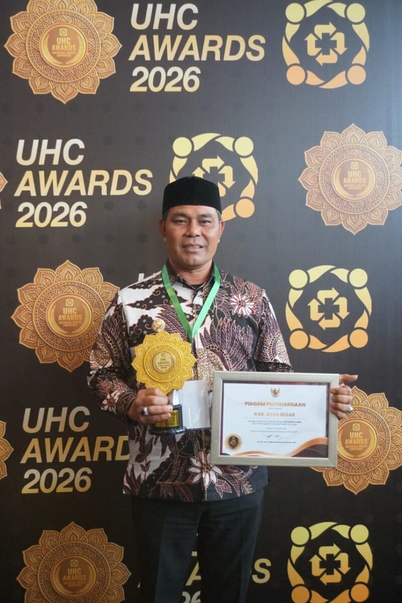 Bupati Aceh Besar H Muharram Idris (Syech Muharram) memperlihatkan perhargaan yang diraih acara penganugerahan UHC yang digelar di Jakarta International Expo (JIExpo) Kemayoran, Jakarta Pusat, Selasa (27/1/2026). FOTO/ PROKOPIM PEMKAB ACEH BESAR