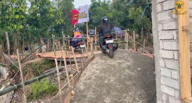 Personel Brimob Polda Sulawesi Tengah bersama TNI dan warga membangun jembatan darurat penghubung Desa Wani 3–Labuan Kungguma pascabanjir di Kabupaten Donggala. Sabtu, 17 Januari 2026.