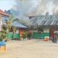 Petugas pemadam kebakaran berupaya memadamkan api yang menghanguskan lima ruang bangunan SDN 5 Kuta Makmur di Desa Blang Talon, Kecamatan Kuta Makmur, Aceh Utara, Jumat (23/1/2026) sore.