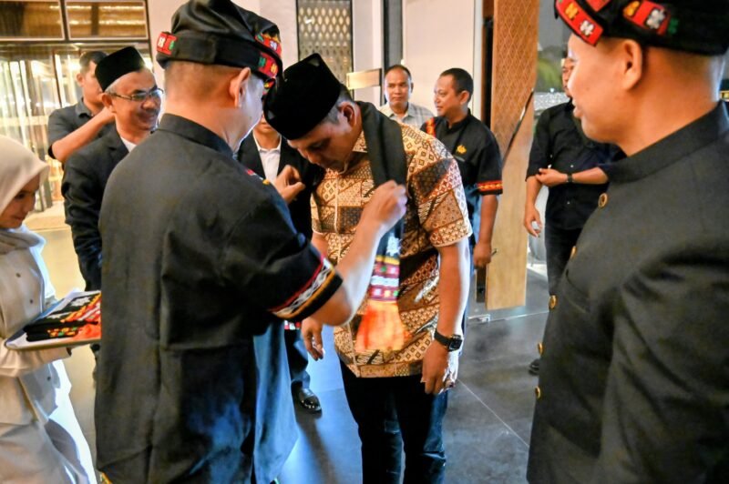 Pengururs KNA mengalungkan sal kepada Bupati Aceh Besar, H Muharram Idris saat tiba di acara Pelantikan Pengurus Keluarga Negeri Antara (KNA) Priode 2025-2030 di The Pade Hotel, Kecamatan Darul Imarah, Aceh Besar, Sabtu (07/02/2026). FOTO/MC ACEH BESAR