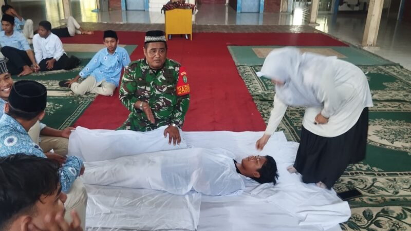 Babinsa Koramil 03/Lhoknga Serda Hazami memberikan materi dan praktik tajhizul jenazah kepada siswa SMA Fajar Hidayah di Blang Bintang, Aceh Besar, sebagai upaya pembinaan karakter religius generasi muda.(25/2/2026).