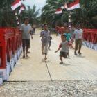 Personel gabungan dari Kodim 0117/Atam, Zidam IM, Yonzipur 10/JP/2 Kostrad, dan Yonif TP 899/BSG saat menyelesaikan tahap akhir pembangunan Jembatan Modular di Desa Tanjung Genteng, Aceh Tamiang, Kamis (26/02/2026).