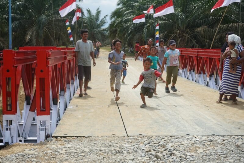Personel gabungan dari Kodim 0117/Atam, Zidam IM, Yonzipur 10/JP/2 Kostrad, dan Yonif TP 899/BSG saat menyelesaikan tahap akhir pembangunan Jembatan Modular di Desa Tanjung Genteng, Aceh Tamiang, Kamis (26/02/2026).