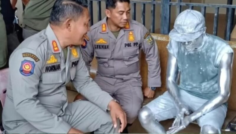 Petugas Satpol PP-WH Kota Banda Aceh menertibkan seorang manusia silver di Simpang Keutapang, Jalan Soekarno-Hatta, Rabu (4/2/2026).