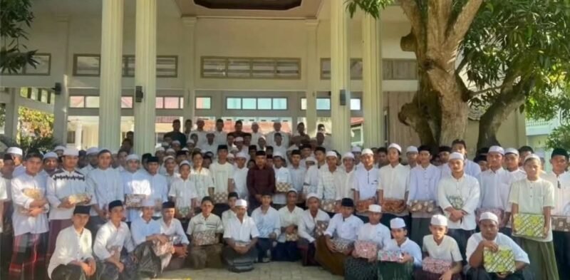 Pengurus Rumah Yatim Dayah Ulee Titi bersama pimpinan dayah menyerahkan santunan kitab kepada santri yatim-piatu di lingkungan Dayah Ulee Titi, Aceh Besar, Jumat (6/2/2026).