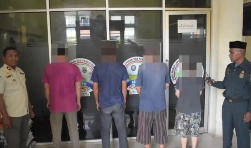 Petugas Satpol PP-WH Aceh melakukan pendataan terhadap pengelola dan pelanggan warung yang kedapatan beroperasi pada siang hari saat operasi penertiban Ramadhan di kawasan Kuta Alam, Banda Aceh, Rabu (25/2/2026).