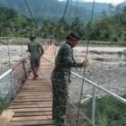 Personel TNI bersama masyarakat memasang lantai dan pagar pengaman pada pembangunan jembatan gantung Desa Mamas Indah, Kecamatan Darul Hasanah, Aceh Tenggara, yang progresnya telah mencapai 87 persen dan segera difungsikan untuk mendukung akses transportasi warga.(1/3/2026).