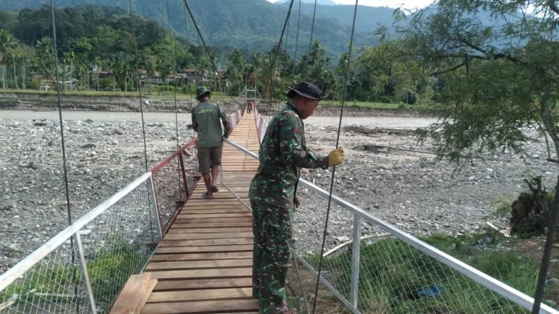 Personel TNI bersama masyarakat memasang lantai dan pagar pengaman pada pembangunan jembatan gantung Desa Mamas Indah, Kecamatan Darul Hasanah, Aceh Tenggara, yang progresnya telah mencapai 87 persen dan segera difungsikan untuk mendukung akses transportasi warga.(1/3/2026).