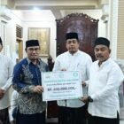 Asisten II Sekretariat Daerah Kabupaten Aceh Besar, M. Ali, S.Sos., M.Si., yang didampingi Kabag Kesra Setdakab Aceh Besar, Zaini, S.H., M.H., menerima santunan dari Baitul Mal Aceh di Masjid Baitul Makmur Sibreh, Rabu (04/03/2026). FOTO/MC ACEH BESAR
