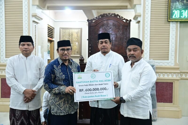 Asisten II Sekretariat Daerah Kabupaten Aceh Besar, M. Ali, S.Sos., M.Si., yang didampingi Kabag Kesra Setdakab Aceh Besar, Zaini, S.H., M.H., menerima santunan dari Baitul Mal Aceh di Masjid Baitul Makmur Sibreh, Rabu (04/03/2026). FOTO/MC ACEH BESAR