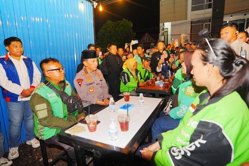 Kapolri Listyo Sigit Prabowo berbincang dengan pengemudi ojek online saat meninjau Kedai Ado Presisi di Sumatera Selatan, Sabtu (7/3/2026) malam, sekaligus menyerap aspirasi dan keluhan para driver terkait pelayanan kepolisian.