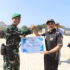 Bupati Pidie Jaya H. Sibral Malasyi menyerahkan penghargaan kepada Danyonif TP 836/Brahma Yodha, Letkol Inf Faishal Riza, saat upacara pelepasan Satgas Gulbencal TNI usai menuntaskan operasi pemulihan pasca bencana hidrometeorologi di Lapangan Gedung MTQ Pidie Jaya, Sabtu (7/3/2026).