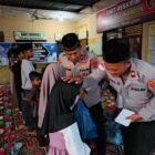 Personel Polsek Seunuddon membagikan paket takjil kepada pengguna jalan di depan Mapolsek Seunuddon, Aceh Utara, Minggu (8/3/2026). Kegiatan tersebut dilanjutkan dengan buka puasa bersama serta pemberian santunan kepada anak-anak yatim.