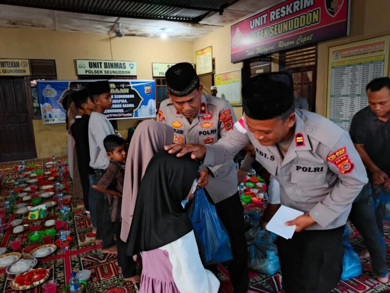 Personel Polsek Seunuddon membagikan paket takjil kepada pengguna jalan di depan Mapolsek Seunuddon, Aceh Utara, Minggu (8/3/2026). Kegiatan tersebut dilanjutkan dengan buka puasa bersama serta pemberian santunan kepada anak-anak yatim.