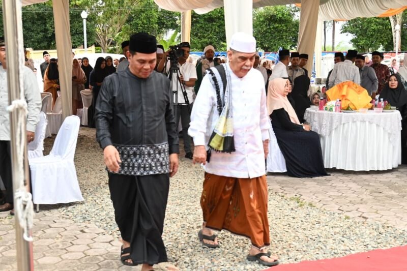 Bupati Aceh Besar, H Muharram Idris menyambut kehadiran Pimpinan Dayah Ulee Titi, Abu. H. Athaillah lshak Al-Amiry (Abu Ulee Titi) pada kegiatan Emplementasi Beut Kitab Bak Sikulah, Santunan Anak Yatim dan Buka Puasa Bersama di Halaman Dekranasda, Gampong Gani, Kecmatan Ingin Jaya, Aceh Besar, Selasa (10/03/2026). FOTO/MC ACEH BESAR