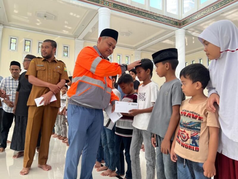 Foto 1: GA & Comrel Manager Solusi Bangun Andalas, Tafaul Rijal menyerahkan santunan anak yatim di Mesjid Kemukiman Kueh yang disaksikan oleh Asisten I Sekretaris Daerah (Sekda) Aceh Besar, Farhan AP dan tokoh masyarakat, 10 Maret 2026.