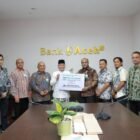 Direktur Utama Bank Aceh Syariah Fadhil Ilyas menyerahkan secara simbolis zakat karyawan Bank Aceh sebesar Rp1,43 miliar kepada perwakilan Baitul Mal Aceh dan Baitul Mal Kota Banda Aceh di Kantor Pusat Bank Aceh, Banda Aceh, Kamis (12/3).