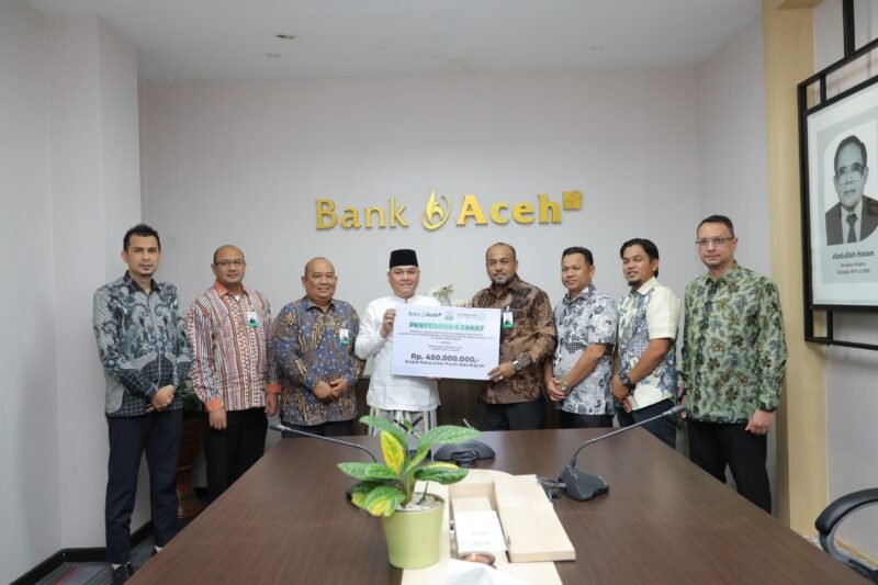 Direktur Utama Bank Aceh Syariah Fadhil Ilyas menyerahkan secara simbolis zakat karyawan Bank Aceh sebesar Rp1,43 miliar kepada perwakilan Baitul Mal Aceh dan Baitul Mal Kota Banda Aceh di Kantor Pusat Bank Aceh, Banda Aceh, Kamis (12/3).