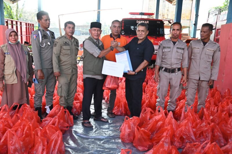 Kalaksa Badan BPBD Aceh Besar, Ridwan Jamil SSos MSi, menyerahkan secara simbolis daging sapi kepada Camat Krueng Barona Jaya, Sayusi, SE untuk masyarakat terdampak banjir di Pos Induk Sibreh, Kecamatan Sukamakmur, Aceh Besar, Kamis (19/03/2026). FOTO/MC ACEH BESAR