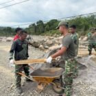 Personel Kodam Iskandar Muda bersama warga melakukan pemasangan jembatan Armco di salah satu titik strategis di wilayah Aceh Utara, Minggu (22/3/2026).